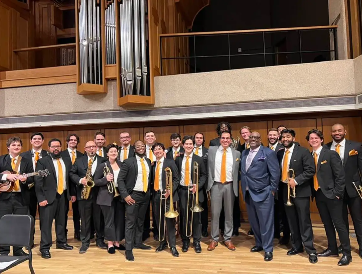 The UT Jazz Orchestra in formal dress with burnt orange ties on the recital hall stage