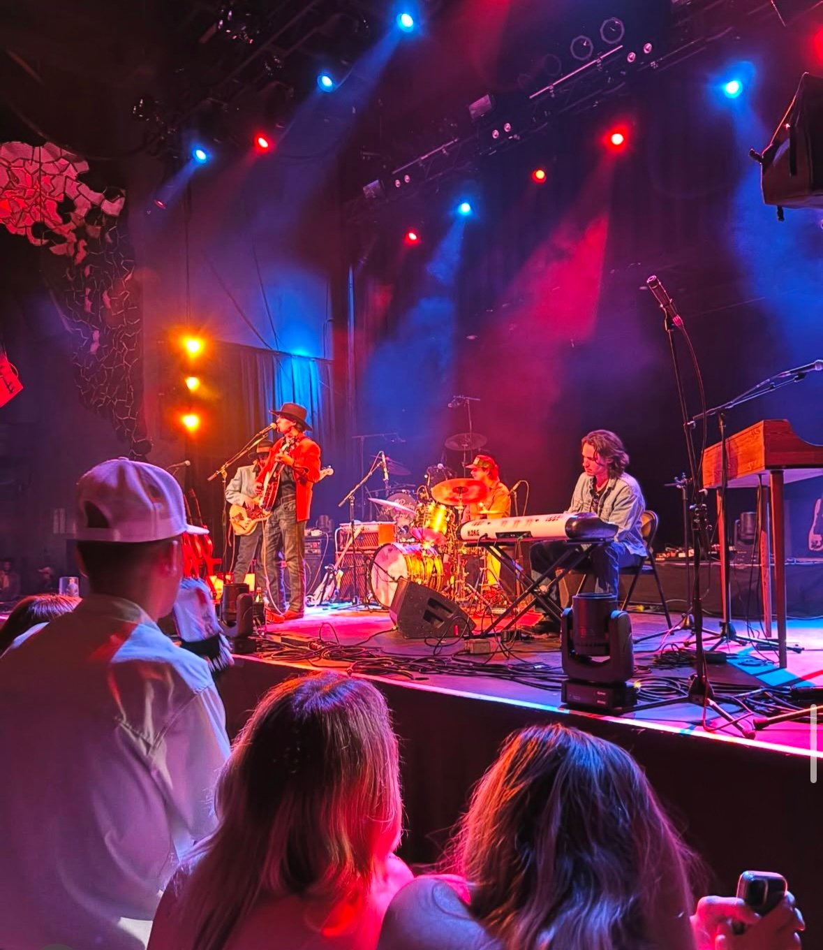 Full band on stage in red and blue lights at House of Blues Austin