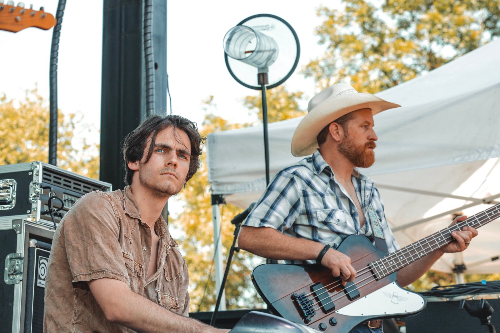 Outdoor stage with bassist in a cowboy hat